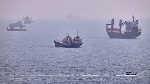 A small boat sails past cargo ships and other commercial vessels anchored in the Strait of Hormuz off Bandar Abbas, Iran, Wednesday, Aug. 5, 2026. (Amirhosein Khorgooi/ISNA vi