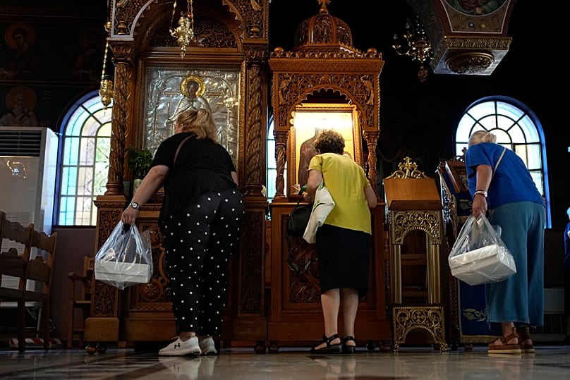 Πιστοί με πίτες προσκυνούν τις εικόνες