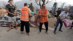 13 أغسطس 2021 - متطوعون يوزعون المؤن على قرية أشلوف بالقبائل شرق الجزائر، بعد حرائق الغابات المدمرة. 