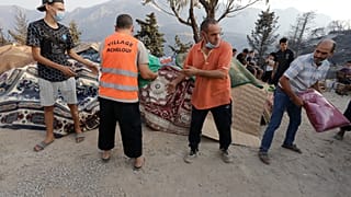 13 أغسطس 2021 - متطوعون يوزعون المؤن على قرية أشلوف بالقبائل شرق الجزائر، بعد حرائق الغابات المدمرة. 