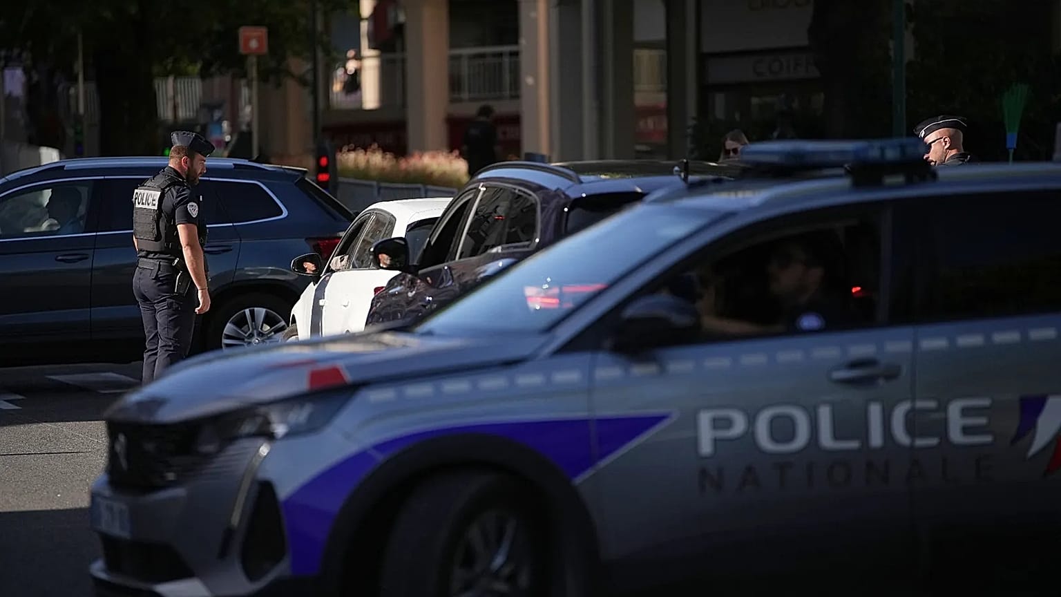 A French police officer is checking vehicles.