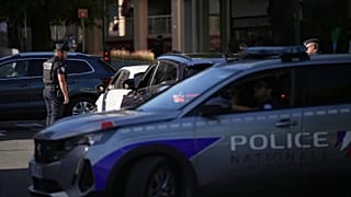A French police officer is checking vehicles.