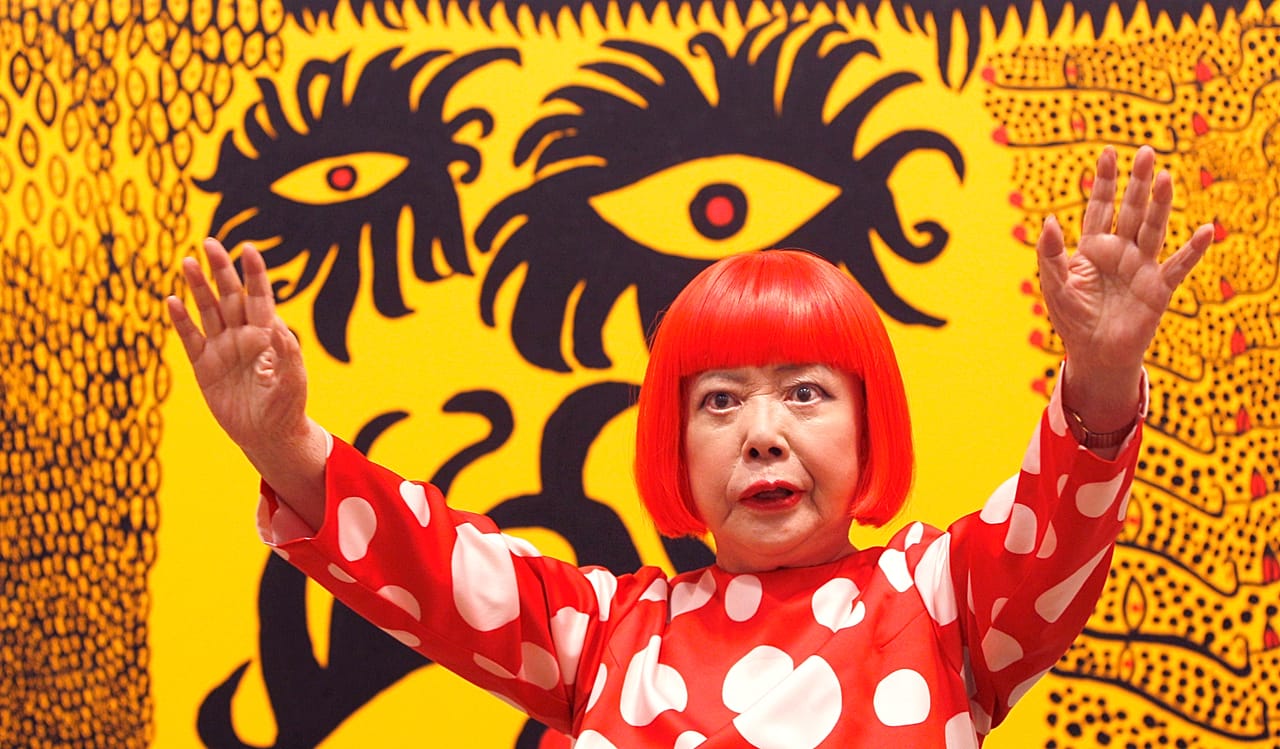 Yayoi Kusama posiert für Fotografen vor ihrem Gemälde „Love Arrives at the Earth Carrying with it a Tale of the Cosmos“ in der Tate Modern in London - 2012