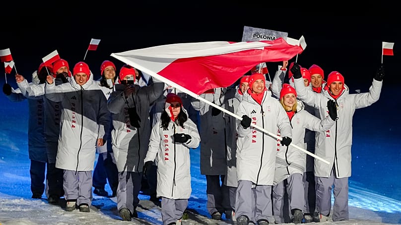 Poland’s flag bearer takes part in the athletes parade during the Olympic opening ceremony at the 2026 Winter Olympics in Predazzo, 6 February, 2026