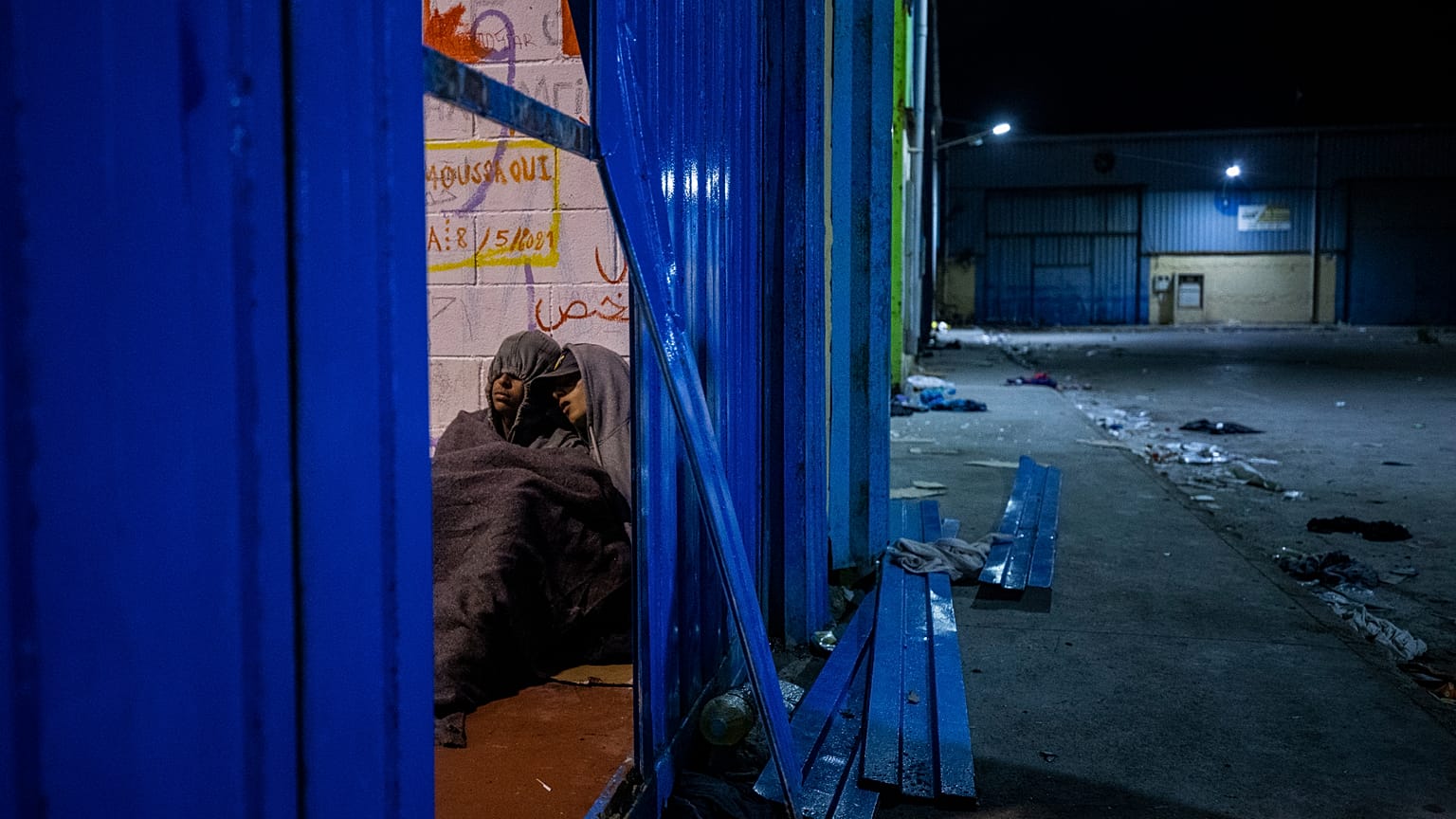 Dos menores duermen dentro de un almacén convertido en un centro improvisado para menores migrantes en el enclave español de Ceuta, en la frontera entre Marruecos y España, en