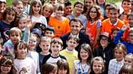 Foto de archivo, el presidente francés Emmanuel Macron posa con niños en un colegio de La Cluze-et-Mijoux, cerca de Besançon, en el este francés, jueves 27 de abril de 2023.