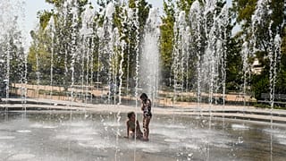 ARQUIVO: Crianças brincam numa fonte de água durante uma onda de calor em Atenas.