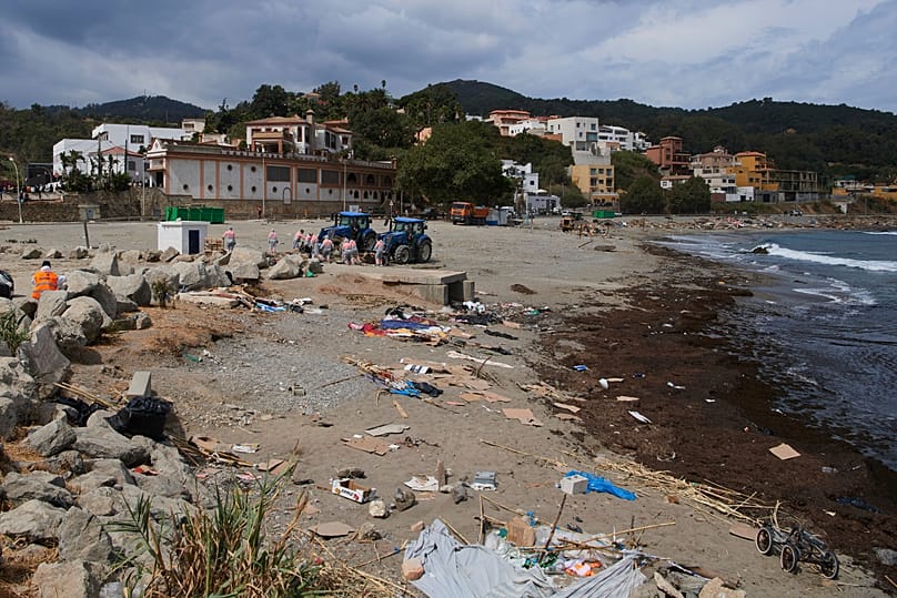 Cleaning staff clear the El Trampolin beach where migrants who crossed from Morocco into the Spanish exclave of Ceuta stayed, 20 August, 2026