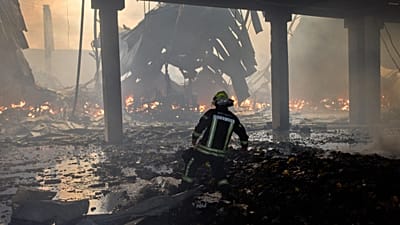 A firefighter tries to extinguish a fire in a destroyed warehouse after Russian drone attacks on the outskirts of Kyiv, 27 August, 2026