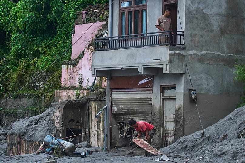 A person moves debris amid damage in the aftermath of flash floods in Devighat in the Nuwakot district in Nepal, 27 August, 2026