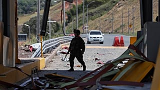 ARCHIVO - Un soldado camina por una caseta de peaje de la Carretera Panamericana, dañada por una explosión atribuida a grupos disidentes de las FARC, el 8 de agosto de 2026.
