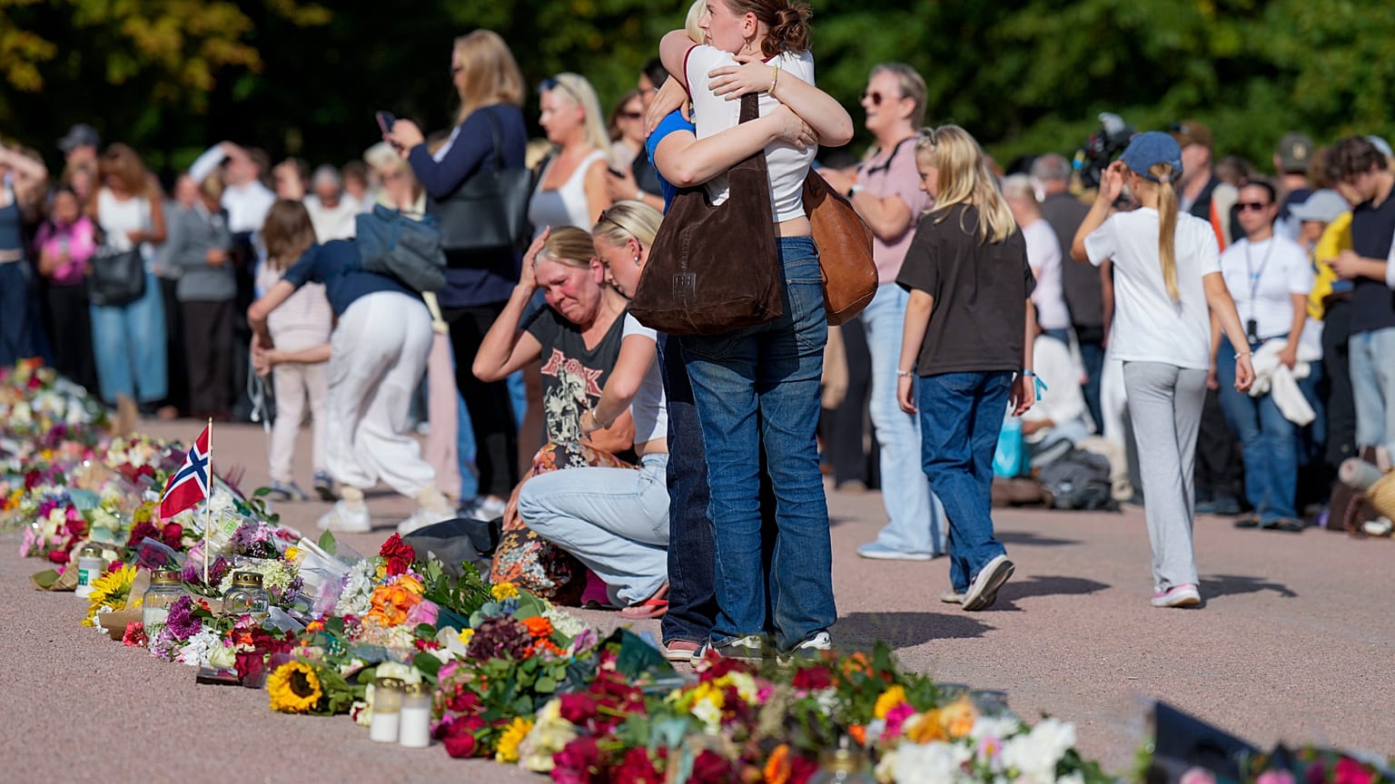 Persone si abbracciano e depongono fiori a Slottsplassen dopo che le autorità hanno detto che il re Harald di Norvegia è in "condizioni molto gravi".