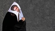 An Iranian woman carries a poster of the Supreme Leader Ayatollah Mojtaba Khamenei
