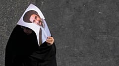 An Iranian woman carries a poster of the Supreme Leader Ayatollah Mojtaba Khamenei