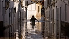 A resident walks along a flooded street in Lora del Rio, southern Spain, Thursday, Dec. 9, 2010.