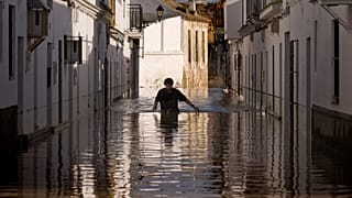 Un residente cammina lungo una strada allagata a Lora del Rio, nel sud della Spagna, giovedì 9 dicembre 2010.