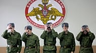FILE: Russian military conscripts don their hats under a sign saying "The Armed Forces of the Russian Federation" at a conscription point in downtown Moscow, 26 May 2010