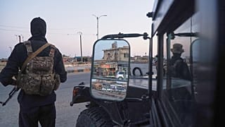 Soldiers formerly with the Kurdish-led Syrian Democratic Forces stand guard in Hasakah, northeastern Syria, 26 August 2026