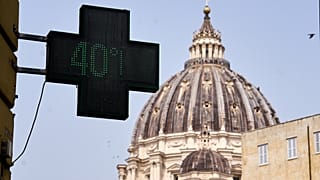 На табло термометра у аптеки на фоне базилики Святого Петра — 40 градусов Цельсия, Рим, пятница, 28 августа 2026 года. (Фото AP/Паоло Санталучия)