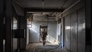 عنصر من قوات الأمن السورية الجديدة يتفقد أروقة زنازين سجن صيدنايا العسكري على أطراف دمشق، في 12 يناير/كانون الثاني 2025.