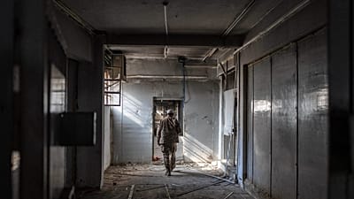 عنصر من قوات الأمن السورية الجديدة يتفقد أروقة زنازين سجن صيدنايا العسكري على أطراف دمشق، في 12 يناير/كانون الثاني 2025.