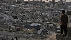 فلسطينيون يسيرون وسط الدمار الذي خلفه الهجوم الجوي والبري الإسرائيلي في حي الشيخ رضوان بمدينة غزة