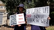 Israeli activists hold up placards in front of the European Union representative offices in east Jerusalem