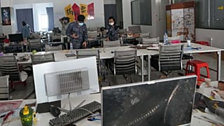 Soldiers inspect a work station at the scam compound in O'Smach, Cambodia, Tuesday, April 7, 2026