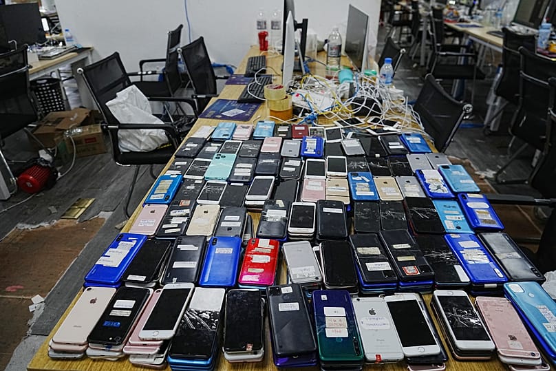 Equipment confiscated in a raid by Cambodian police are laid out on a table at a scam centre in Phnom Penh, 11 March, 2026
