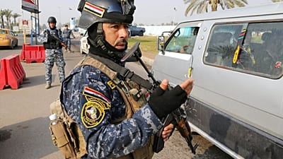 يقف عناصر من الشرطة الاتحادية العراقية للحراسة عند نقطة تفتيش في بغداد، العراق، يوم الثلاثاء 31 ديسمبر/كانون الأول 2013.