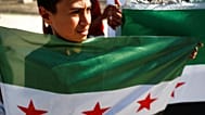 صورة أرشيفية- يرفع شاب العلم السوري أورفا بجنوب شرق تركيا، يوم الاثنين 14 أكتوبر/تشرين الأول .2019