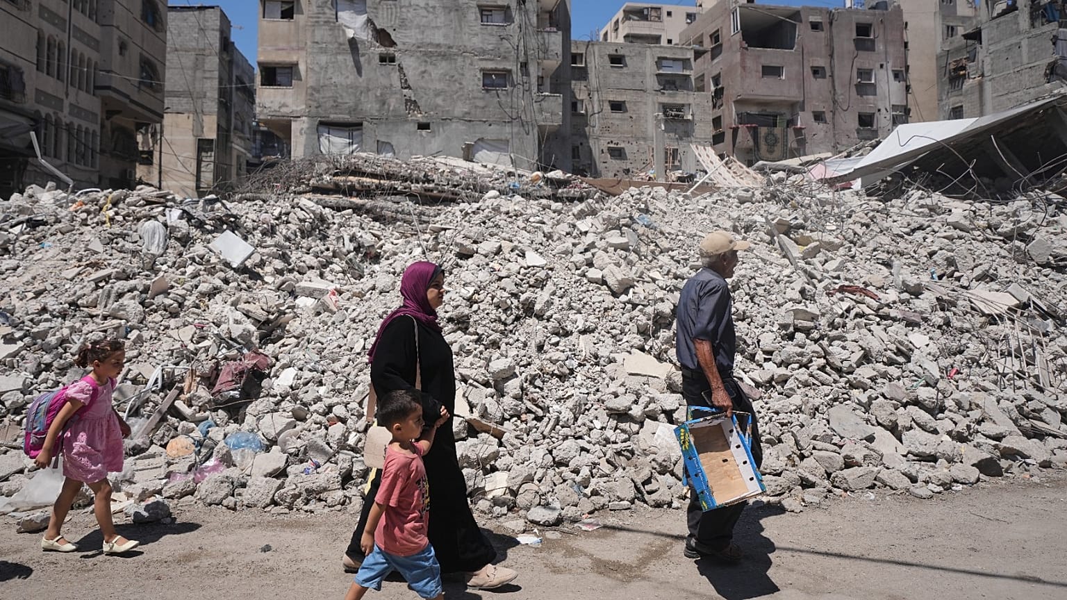 فلسطينيون يسيرون وسط أنقاض المباني التي دمرتها الغارات الجوية الإسرائيلية خلال الحرب مع حماس، في مدينة غزة، الاثنين 24 أغسطس 2026.