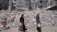 فلسطينيون يسيرون وسط أنقاض المباني التي دمرتها الغارات الجوية الإسرائيلية خلال الحرب مع حماس، في مدينة غزة، الاثنين 24 أغسطس 2026.