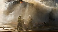 Firefighters try to extinguish a fire at a destroyed warehouse after Russian drone attacks on the outskirts of Kyiv, Ukraine, Friday, Aug. 28, 2026.