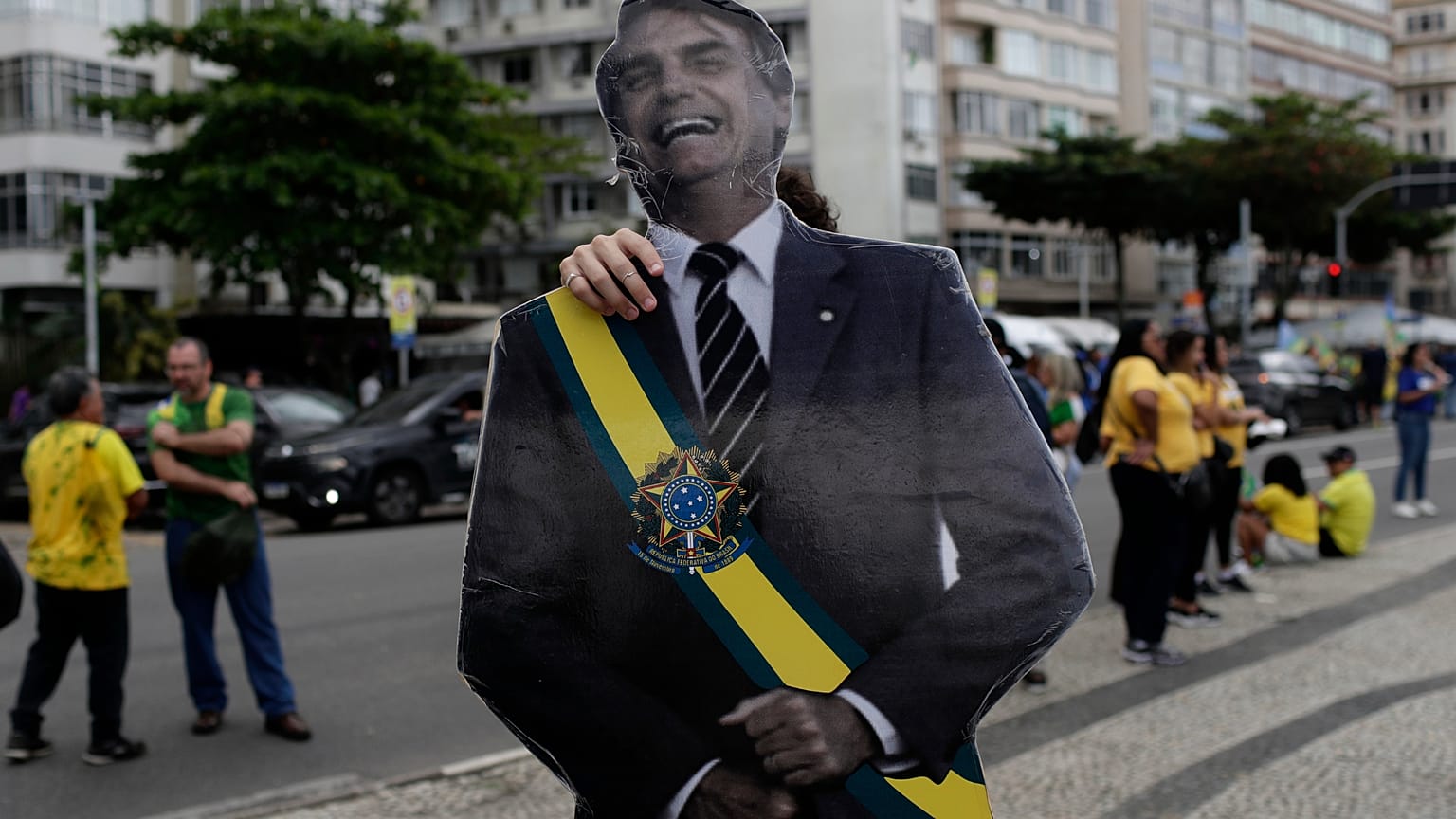 Um apoiante do candidato presidencial da oposição, Flávio Bolsonaro, exibe uma imagem do pai de Flávio Bolsonaro, o ex-presidente Jair Bolsonaro