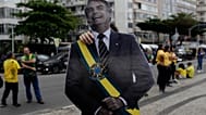 Um apoiante do candidato presidencial da oposição, Flávio Bolsonaro, exibe uma imagem do pai de Flávio Bolsonaro, o ex-presidente Jair Bolsonaro
