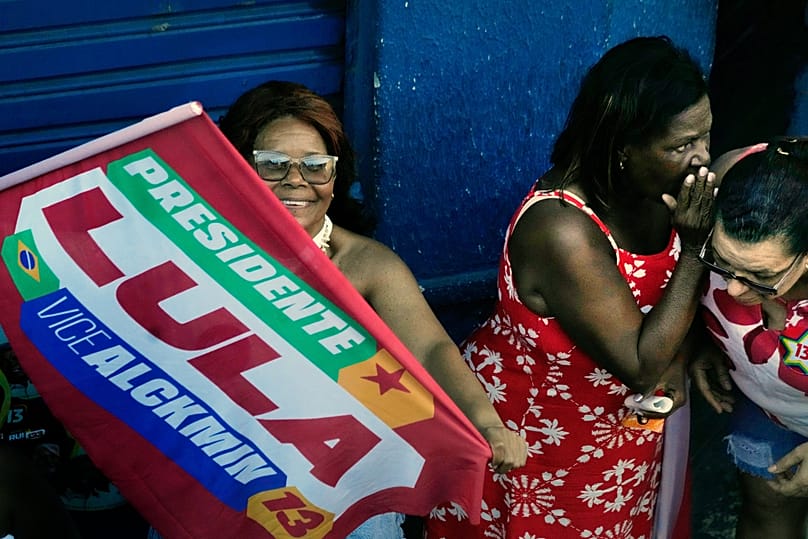 Os apoiantes observam o presidente brasileiro Luiz Inácio Lula da Silva a passar durante um comício de campanha em Salvador, 