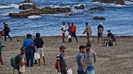 Migrantes que cruzaron de Marruecos a España regresan a una playa tras haber sido expulsados el día anterior, en el enclave español de Ceuta, el 21 de agosto de 2026.