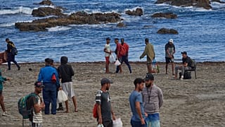 Migrantes que cruzaron de Marruecos a España regresan a una playa tras haber sido expulsados el día anterior, en el enclave español de Ceuta, el 21 de agosto de 2026.