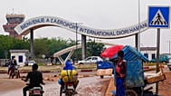 Motorcyclists ride by the entrance of the airport in Niamey, Niger, Aug. 8, 2023.