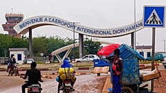 Motorcyclists ride by the entrance of the airport in Niamey, Niger, Aug. 8, 2023.