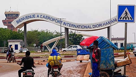Motorcyclists ride by the entrance of the airport in Niamey, Niger, Aug. 8, 2023.