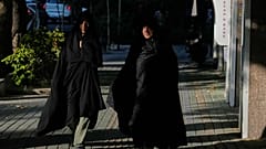 نساء يسيرن على الرصيف في شمال طهران، إيران، الخميس 13 أغسطس 2026. (AP Photo/فاهد سليمي)