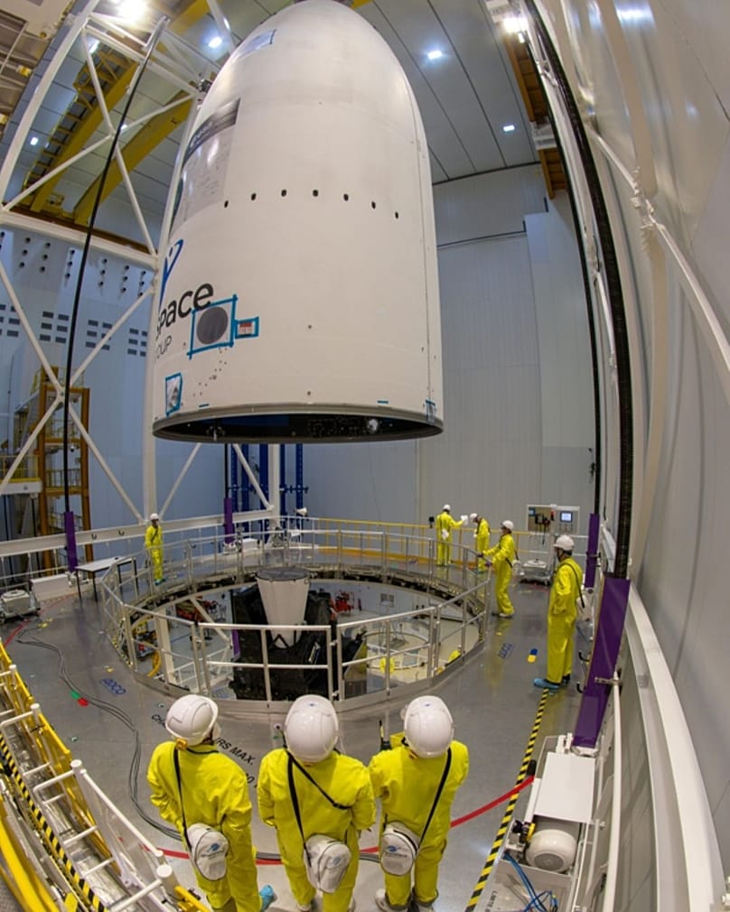 Varios empleados miran cómo el satélite MTG-I2 fue encapsulado en su carenado en la Instalación de Encapsulación Ariane del Puerto Espacial Europeo de Kourou en agosto 2026.