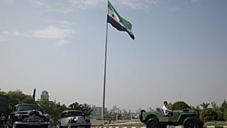 ويتبعه أشقاؤه، بشرى حفار يقود سيارة جيب ويليز، التي قام والده وسيم بترميمها، عبر دمشق، سوريا، الجمعة 14 أغسطس 2026. (AP Photo/غيث السيد)