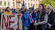 People hold a banner reading "No" as they listen to speakers at an "Afram Island," "Forward, Iceland," rally opposing the resumption of European Union accession talks