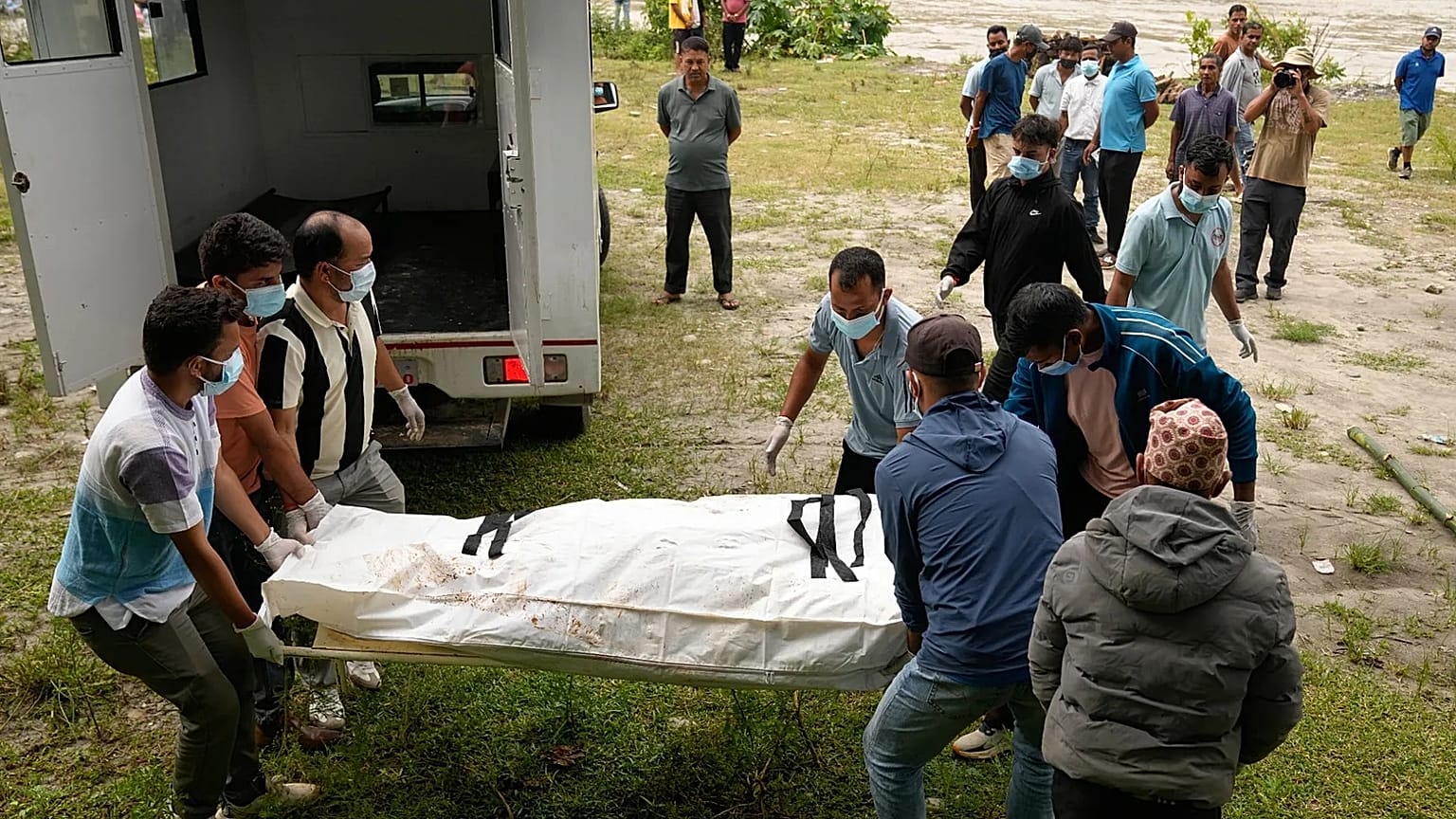 Voluntarios y rescatistas transportan el cuerpo de una víctima de una inundación repentina para su entierro colectivo en Chitwan, Nepal, el lunes 31 de agosto de 2026.