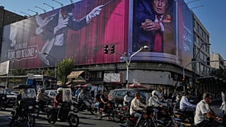  دراجات نارية في طهران أمام لوحة إعلانية كبيرة لترامب، 29 أغسطس 2026.