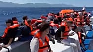 Passengers wearing life jackets wait atop a capsized passenger vessel to be rescued off the coast of Girne, 30 August, 2026