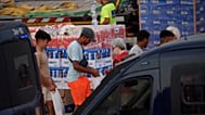 Unos migrantes reciben unos víveres de ayuda